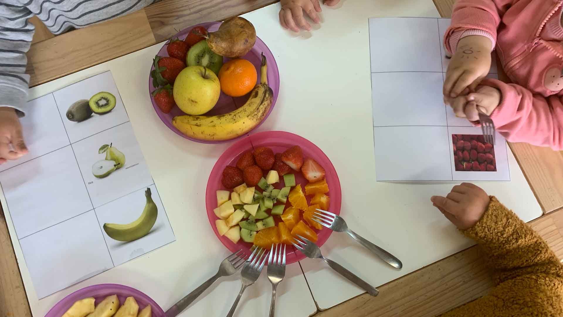 Taula amb fruita i nens